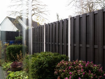 Zwarte schutting van composiet met betonpalen