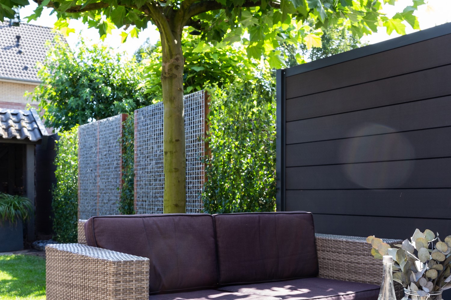 Schanskorven combinatie met composiet schutting en hedera.