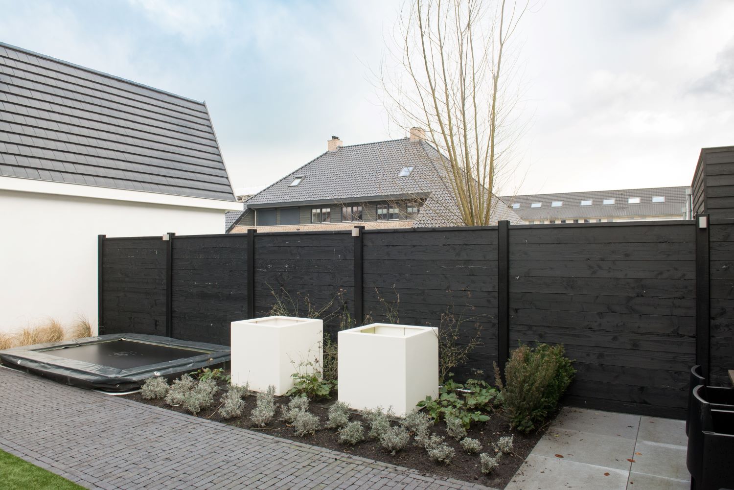 Moderne tuin met zwarte schutting