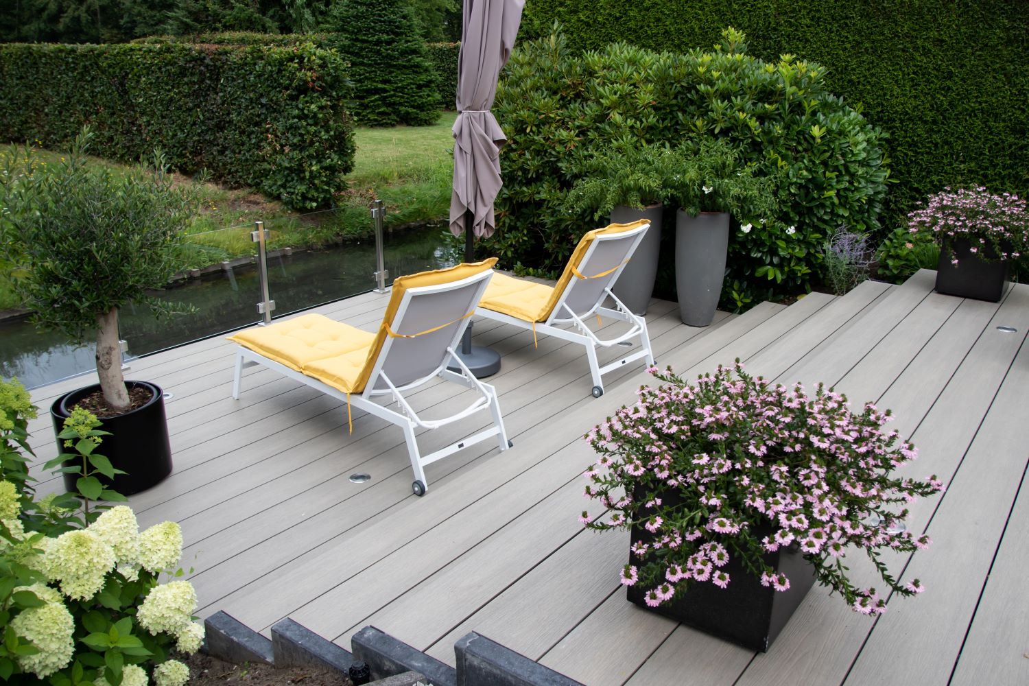 Moderne tuin met composiet vlonder aan het water